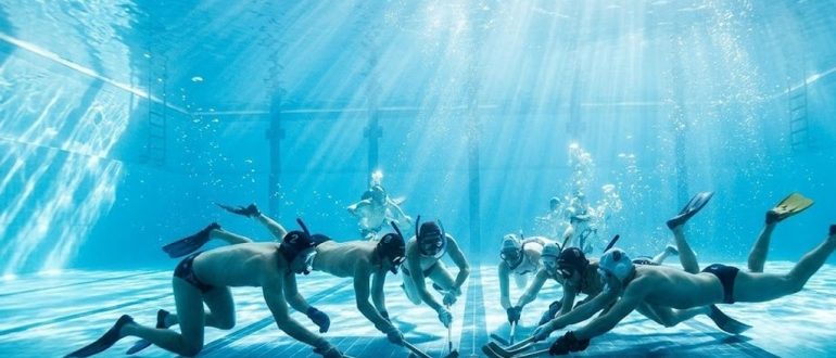 Подводный хоккей в бассейне: игроки в масках и ластах на дне